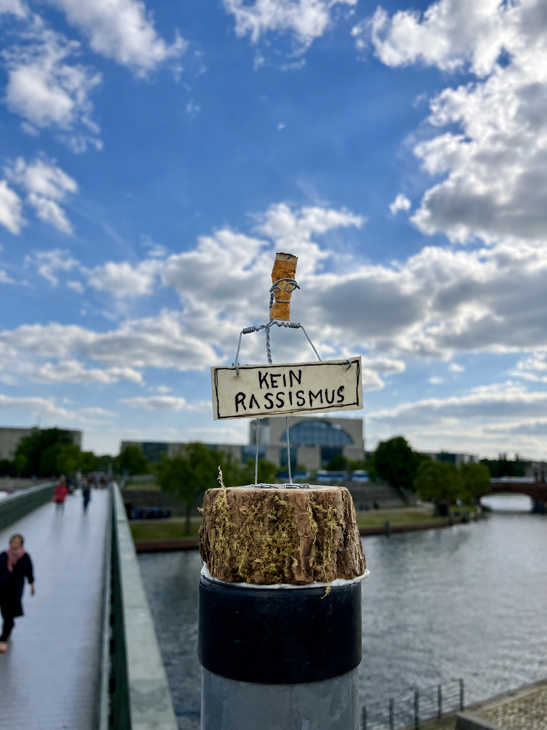 Small Peaceful Demonstrator sculpture holding a civic sign in public space